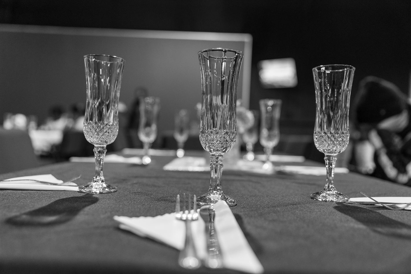 Cut-crystal glasses and folded napkins on a set table before a formal dinner