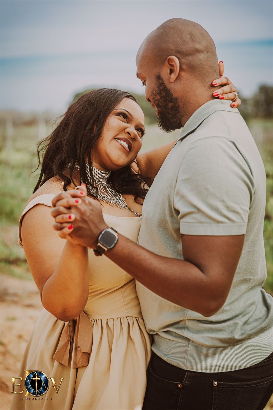 Couple dancing together, hands clasped, in the late afternoon