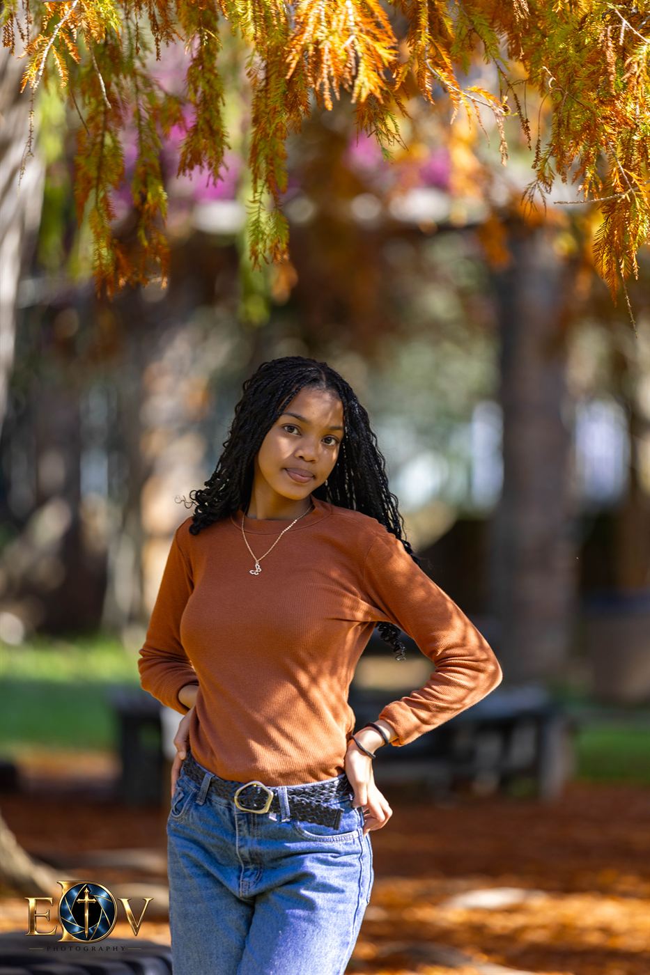 Young woman standing beneath a flowering tree in autumn colour