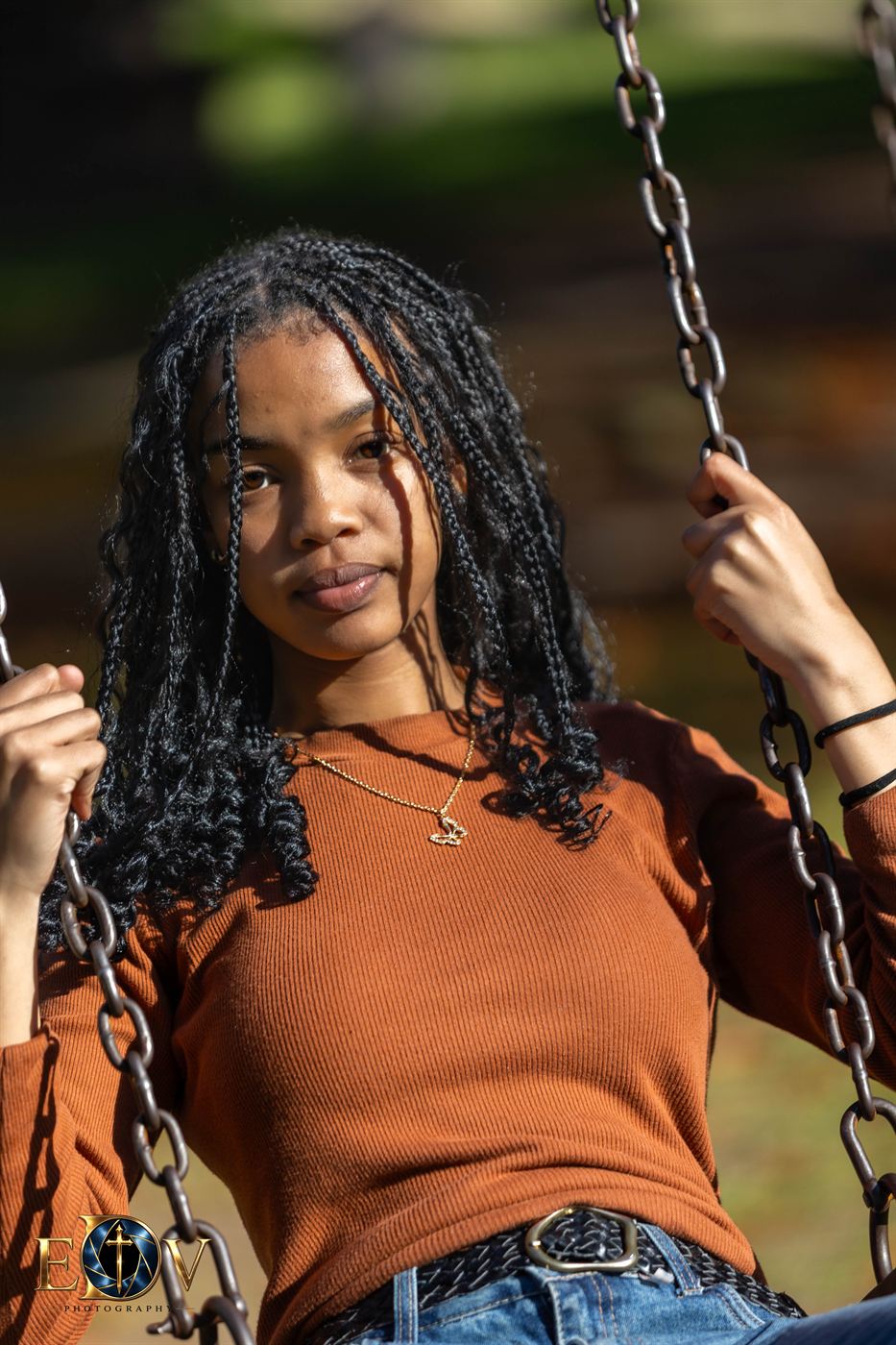 Young woman on a park swing in late afternoon light